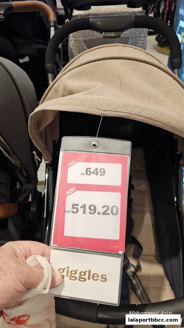A close-up of a stroller with a price tag showing a sale.