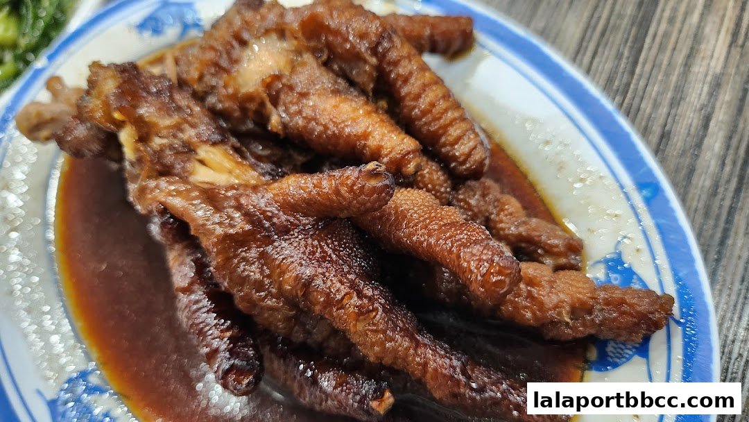 A close-up shot of braised chicken feet in a savory sauce on a blue and white patterned plate.
