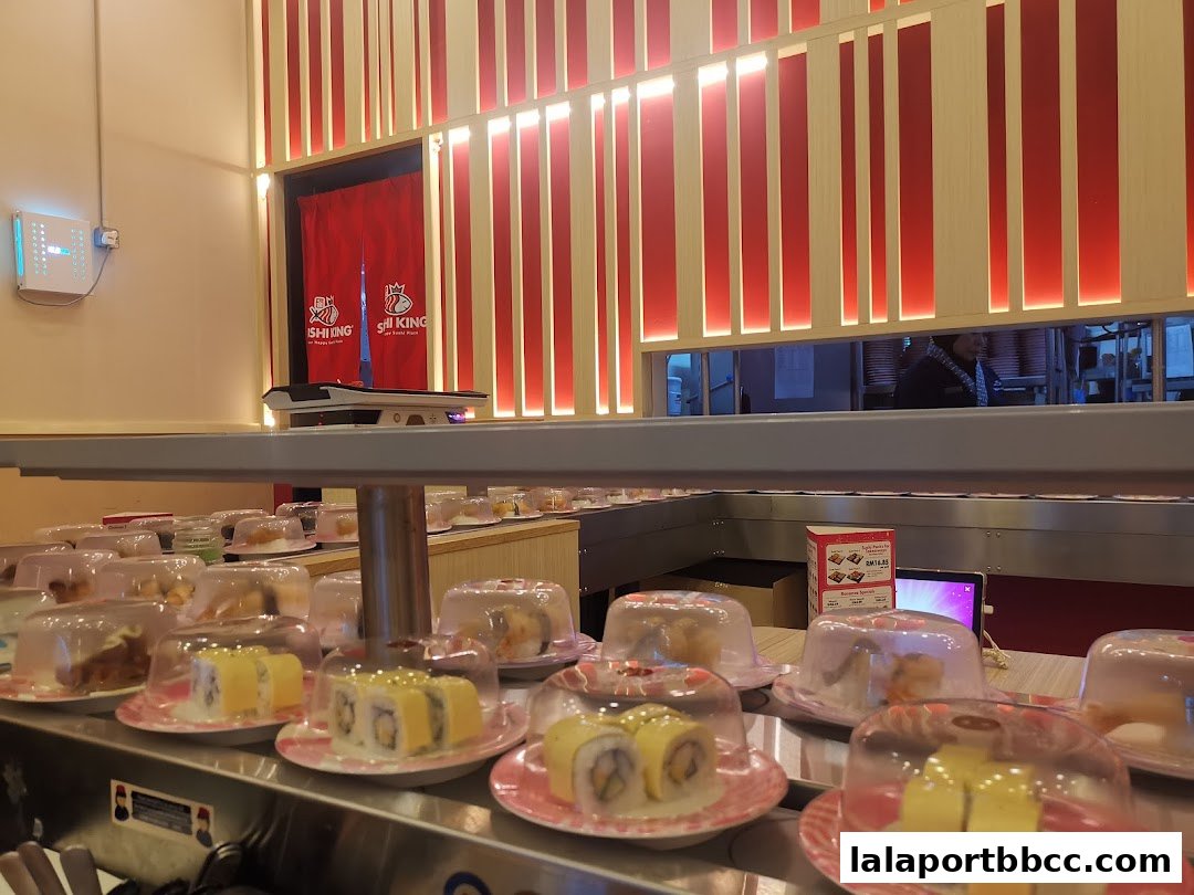 Sushi conveyor belt with various sushi dishes covered and ready to be served.