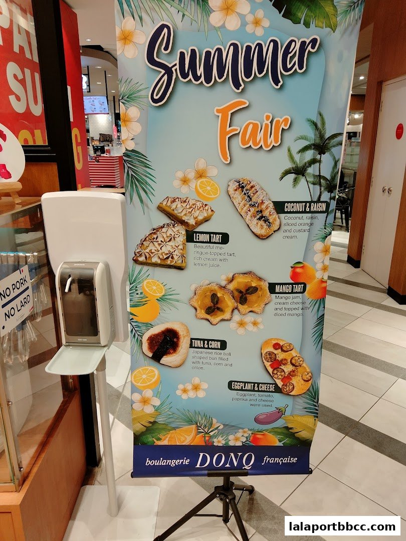 A promotional banner for DONQ boulangerie's Summer Fair featuring various baked goods.