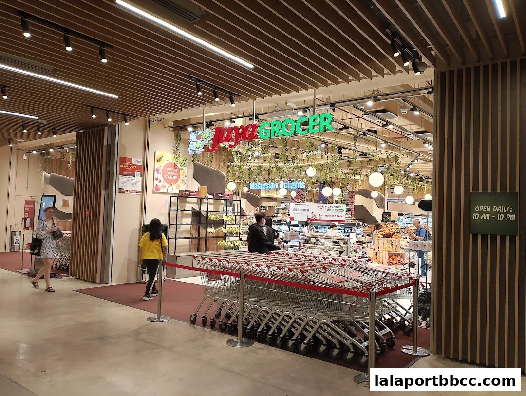 The entrance to Jaya Grocer supermarket with shopping carts and customers.