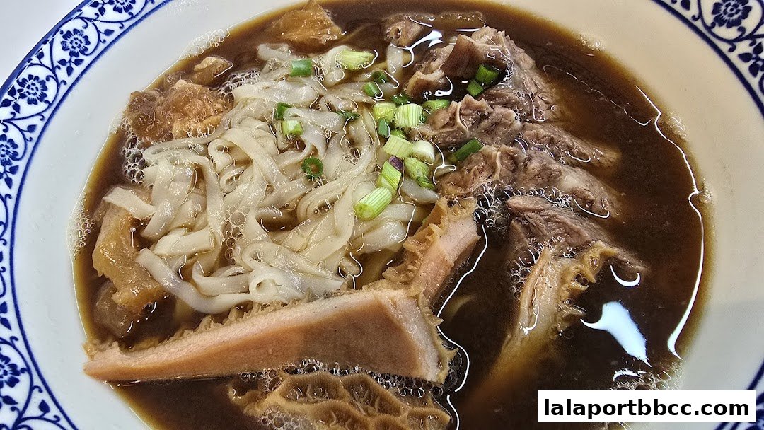A close-up shot of a steaming bowl of Hong Kong-style noodles with beef and tripe.