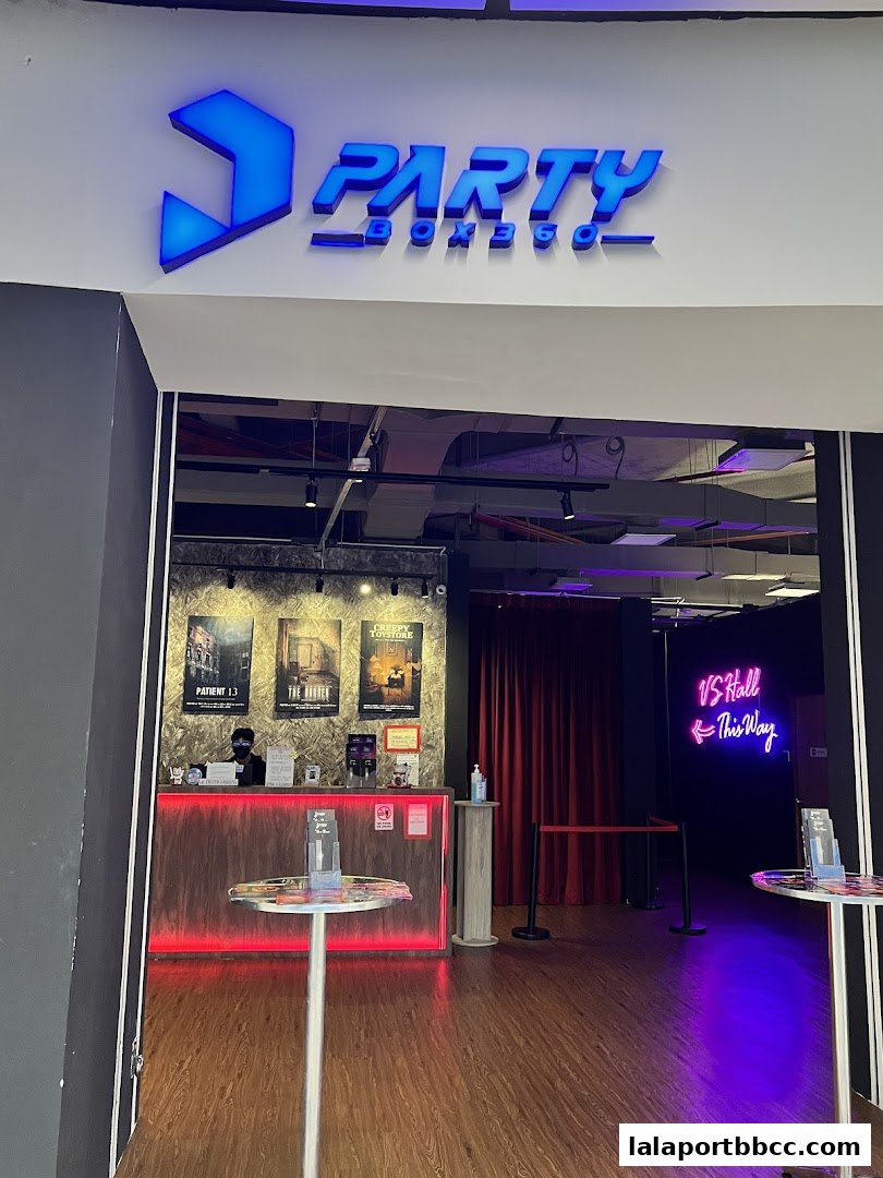 The entrance to PartyBox 360, featuring a reception desk with movie posters and neon signage.