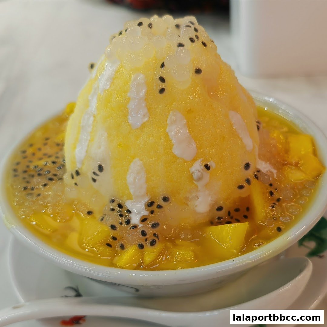 A refreshing bowl of mango shaved ice dessert with basil seeds and mango chunks.