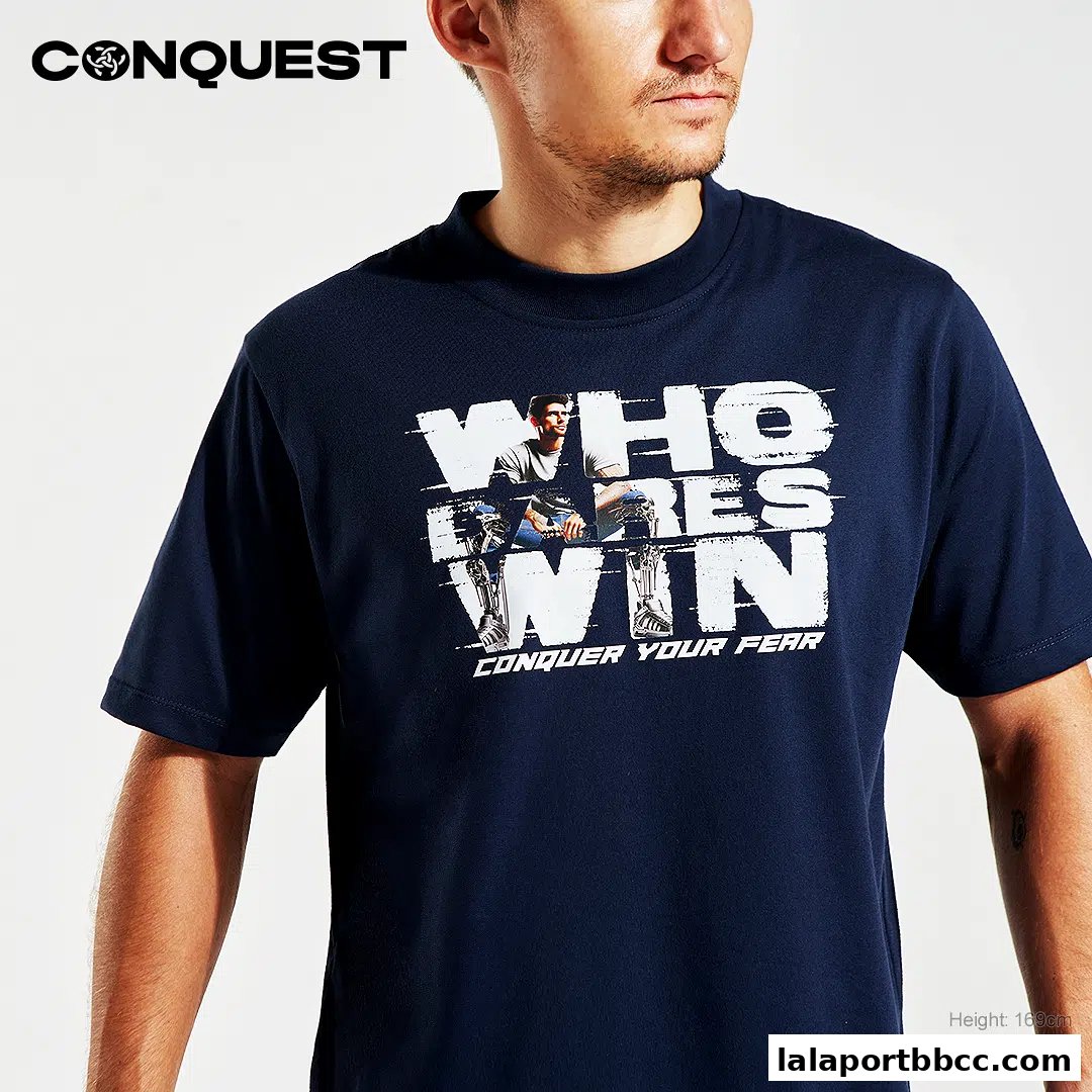 A man wearing a navy blue t-shirt with a graphic print and the CONQUEST logo.