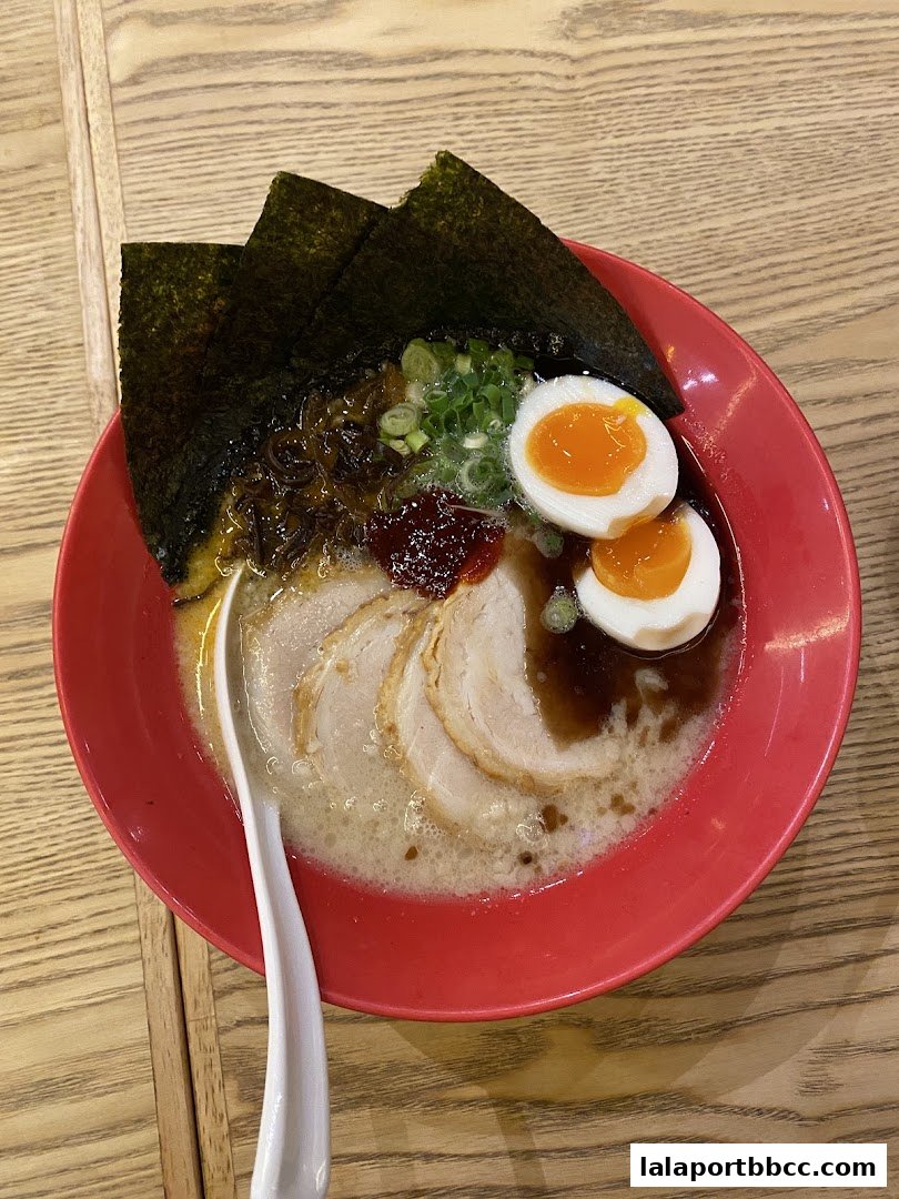 A delicious bowl of ramen with pork slices, soft-boiled eggs, seaweed, and green onions.