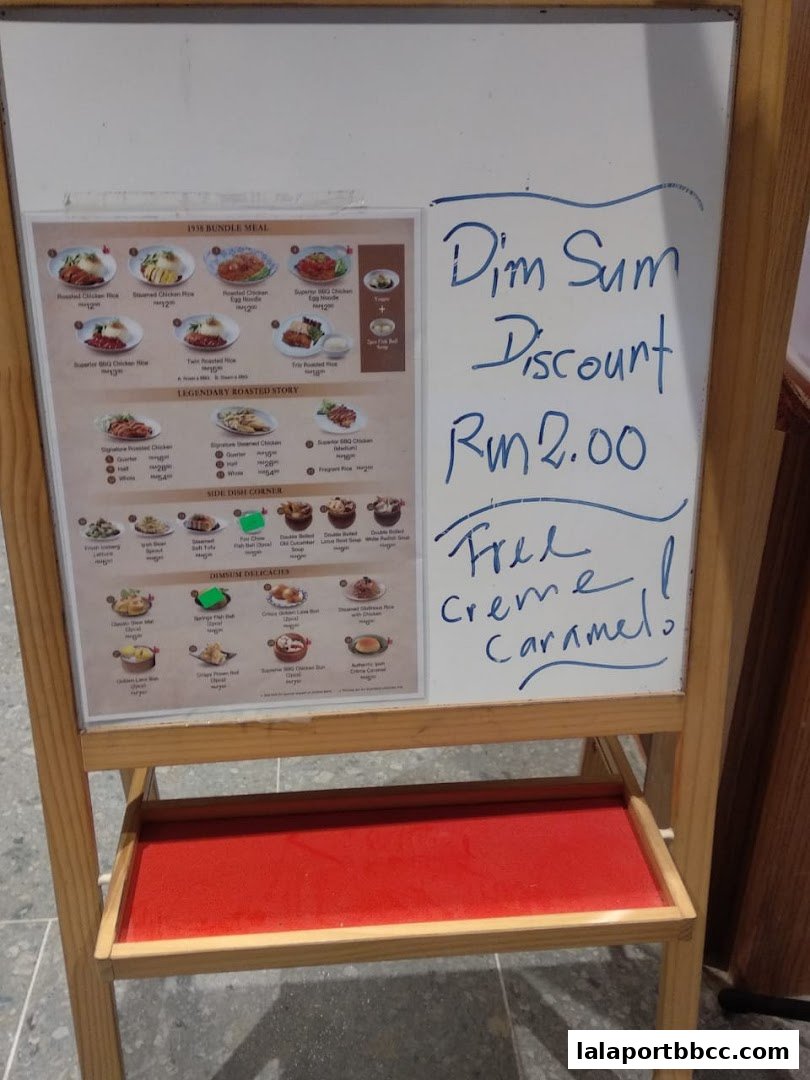 A menu board advertising Dim Sum discounts and various chicken rice dishes.