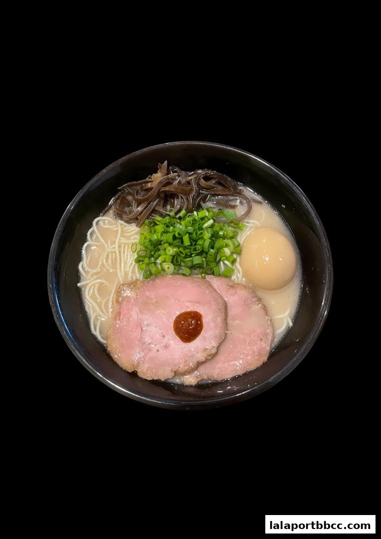 A delicious bowl of ramen with chashu pork, egg, green onions, and wood ear mushrooms.