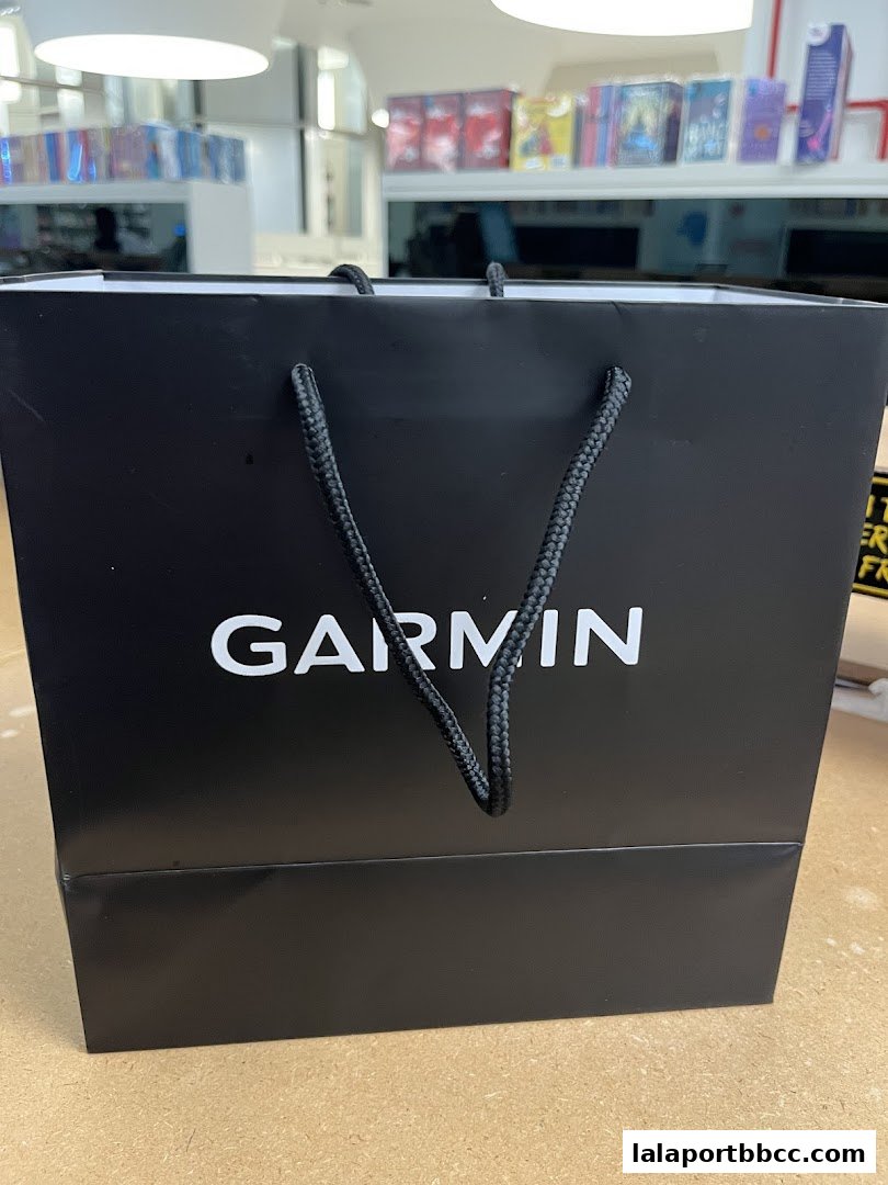 A black shopping bag with the Garmin logo is displayed prominently.