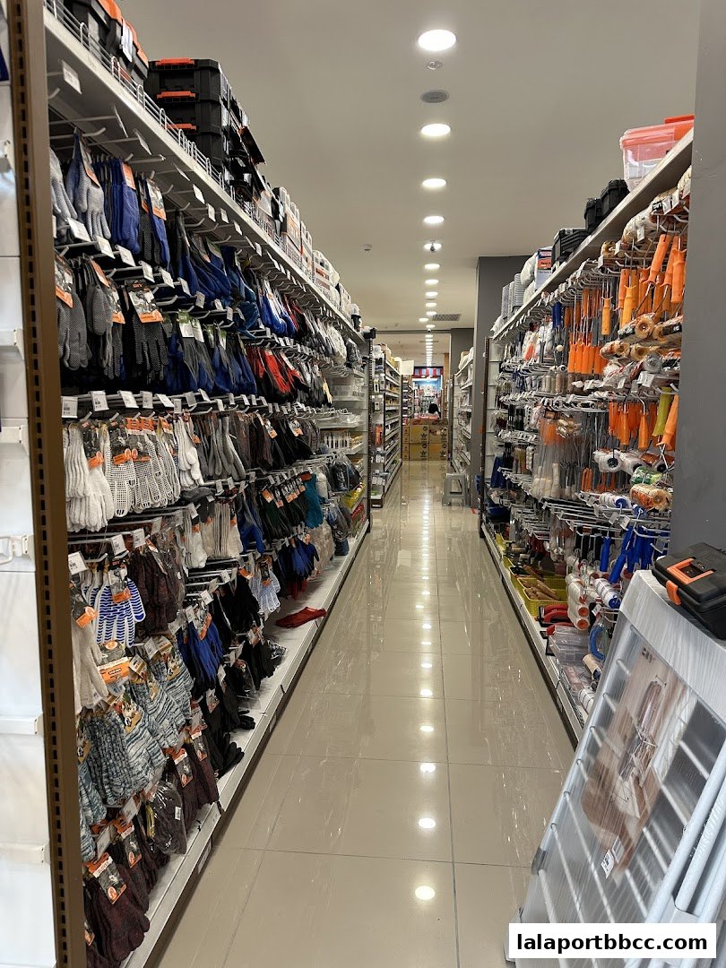 Aisle view of a MR.DIY PLUS store showcasing gloves and tools on shelves.