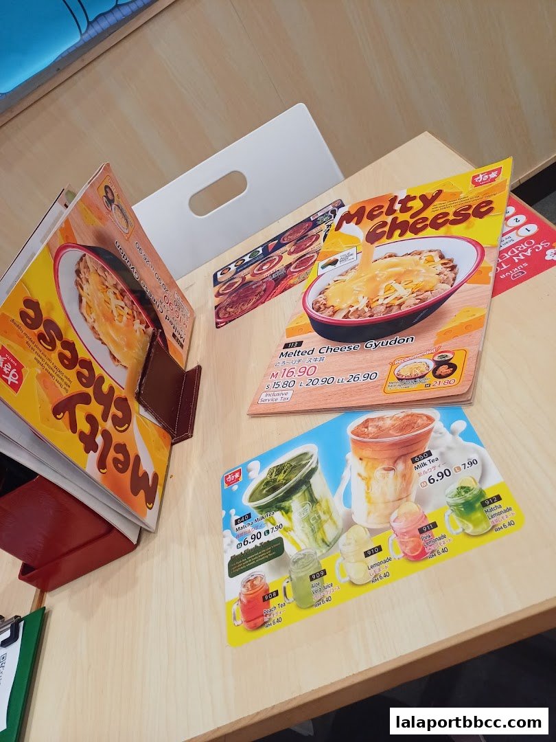 A table displaying menus for Sukiya, featuring Melty Cheese Gyudon and various drinks.