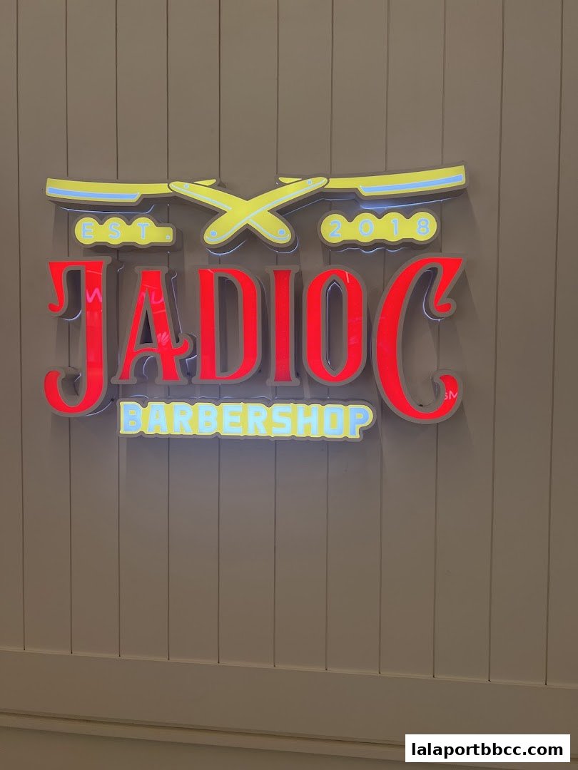 A neon sign for Jadioc Barbershop with a vintage razor design.