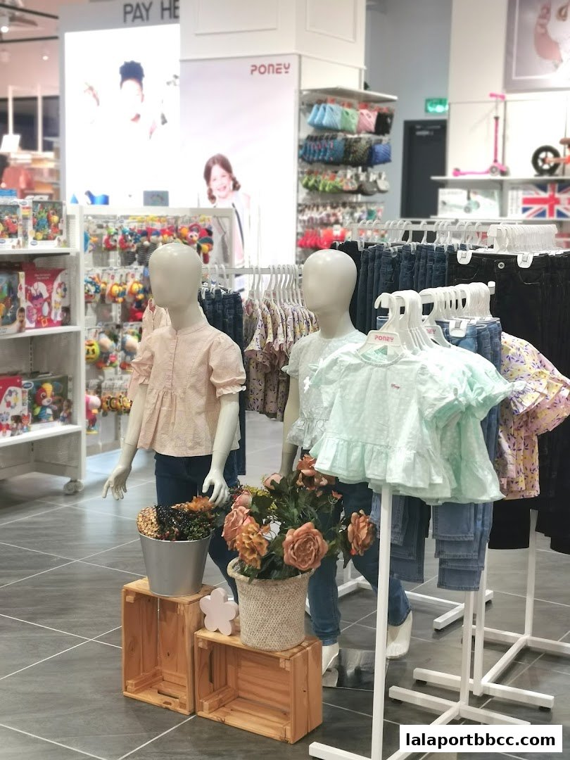 Mannequins display children's clothing in a bright, modern retail store.