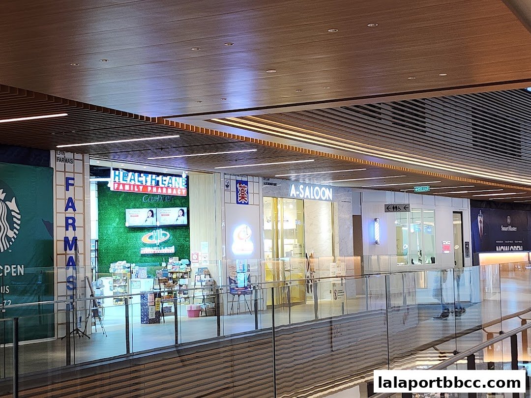 A view of several shops including A-Saloon, Health Lane Family Pharmacy, and Starbucks in a mall.