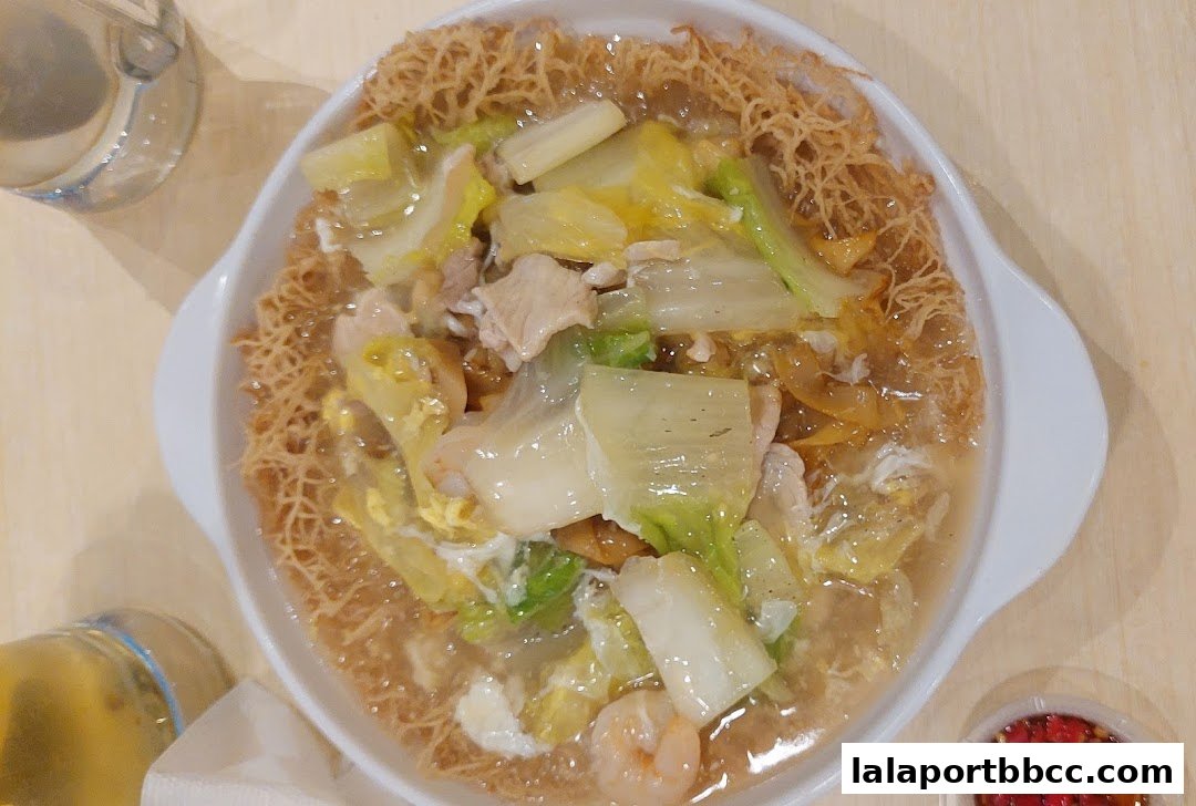 A close-up shot of a crispy noodle dish with vegetables, meat, and shrimp.