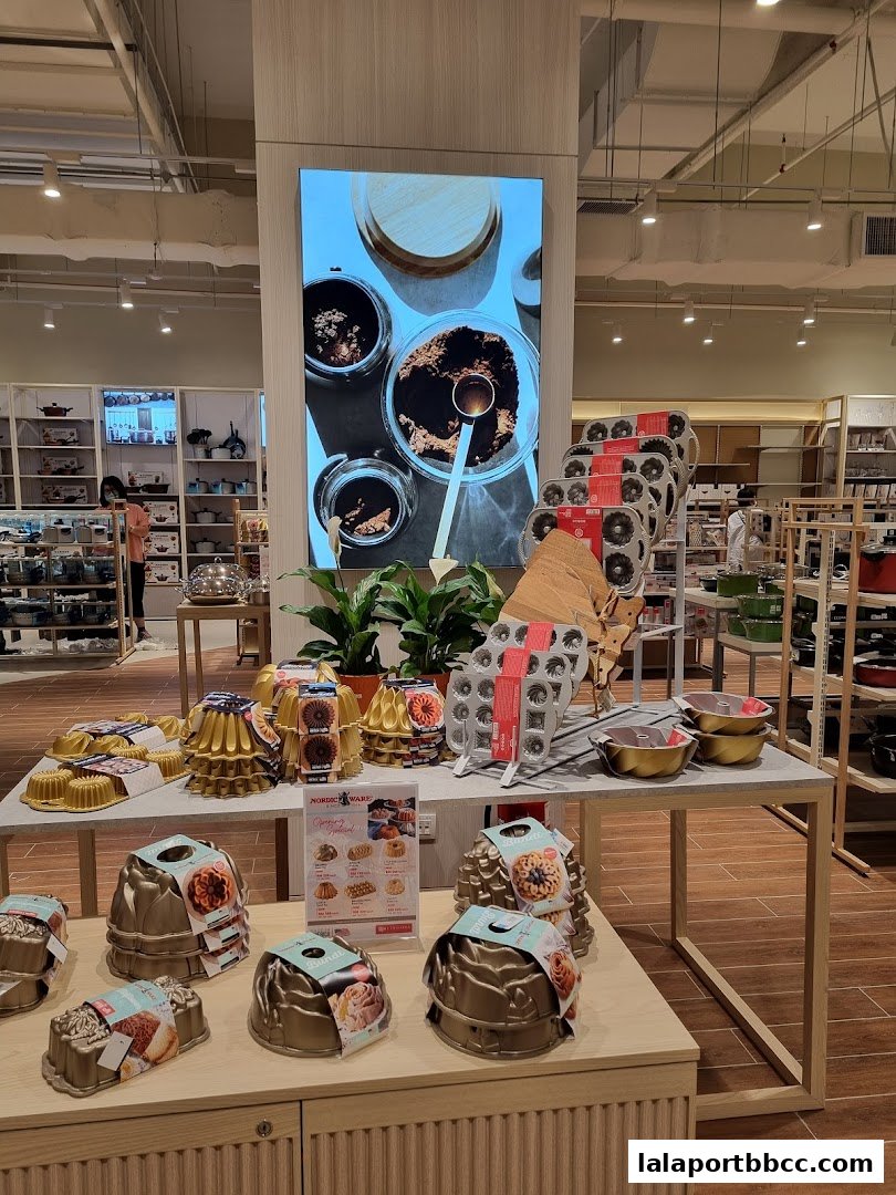 A display of various Nordic Ware cake molds and baking accessories in a retail store.