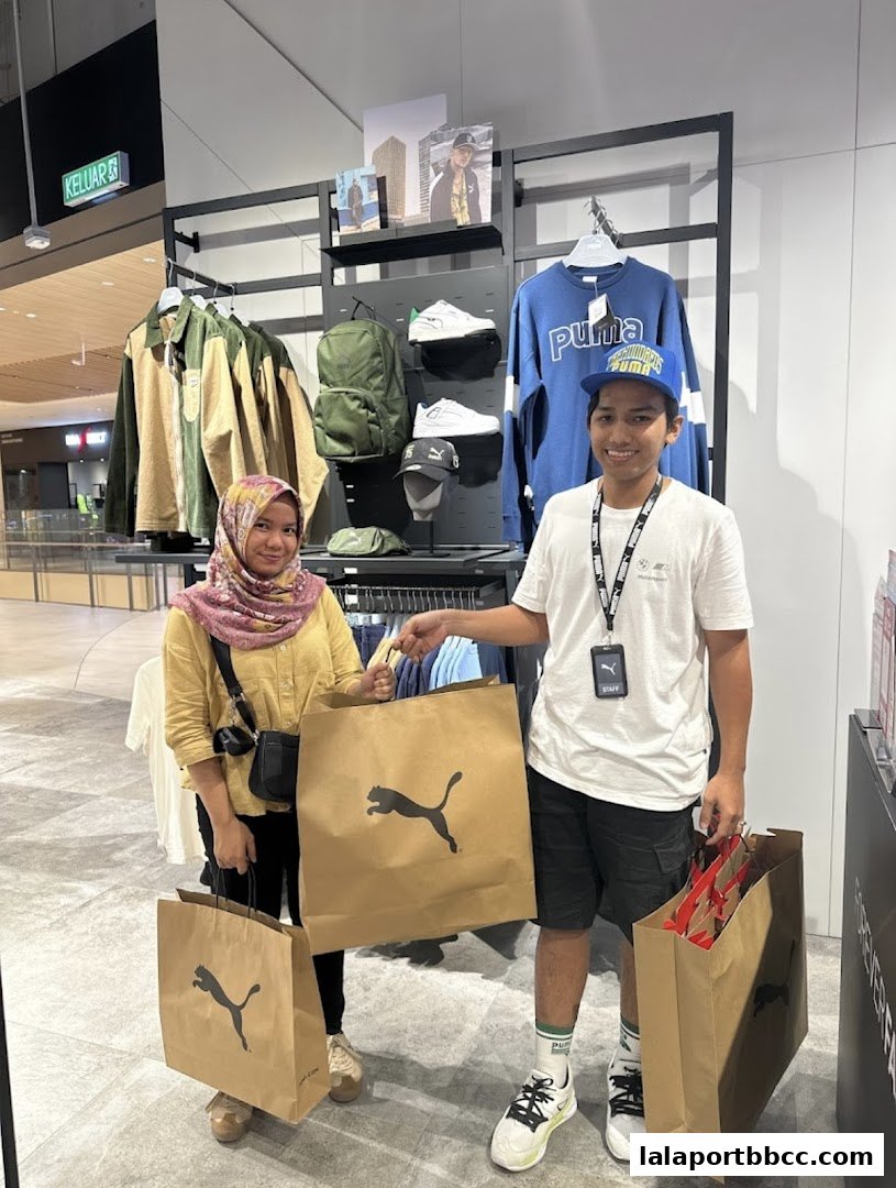 Two shoppers proudly display their PUMA shopping bags filled with merchandise.