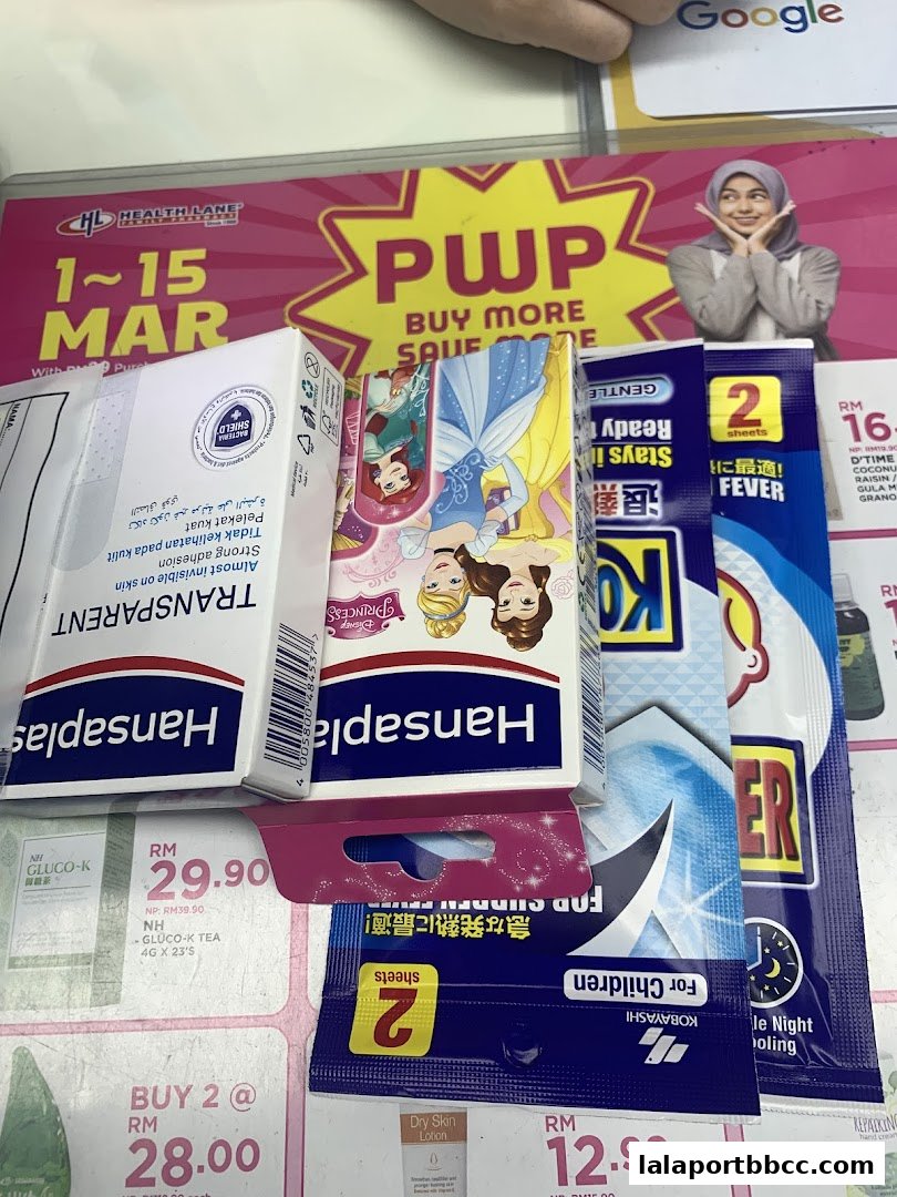 A display of various health and personal care products, including bandages and fever patches, with promotional signage.
