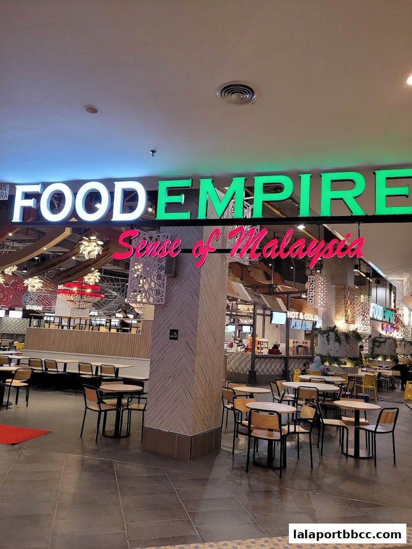 A food court area with tables and chairs, and a large sign reading 'FOOD EMPIRE Sense of Malaysia'.