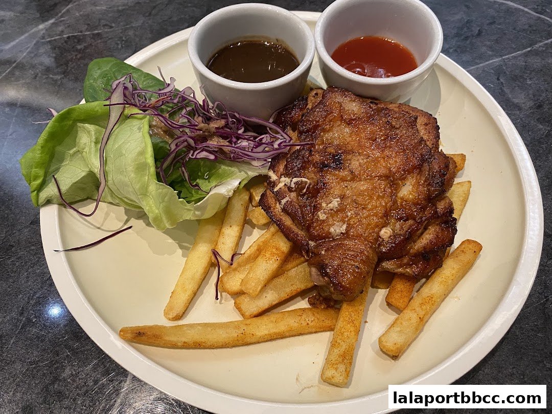 A plate of crispy fried chicken with fries, salad, and dipping sauces.