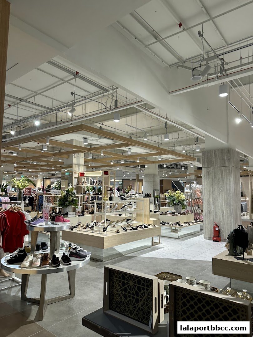 Interior view of a well-lit shoe store with various footwear displayed on shelves and tables.