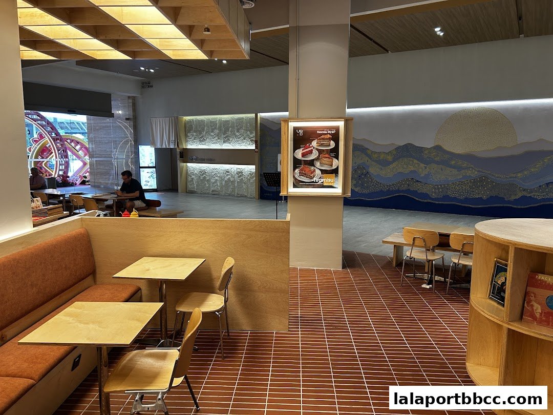 Interior of a cafe with seating, tables, and a decorative mural on the wall.