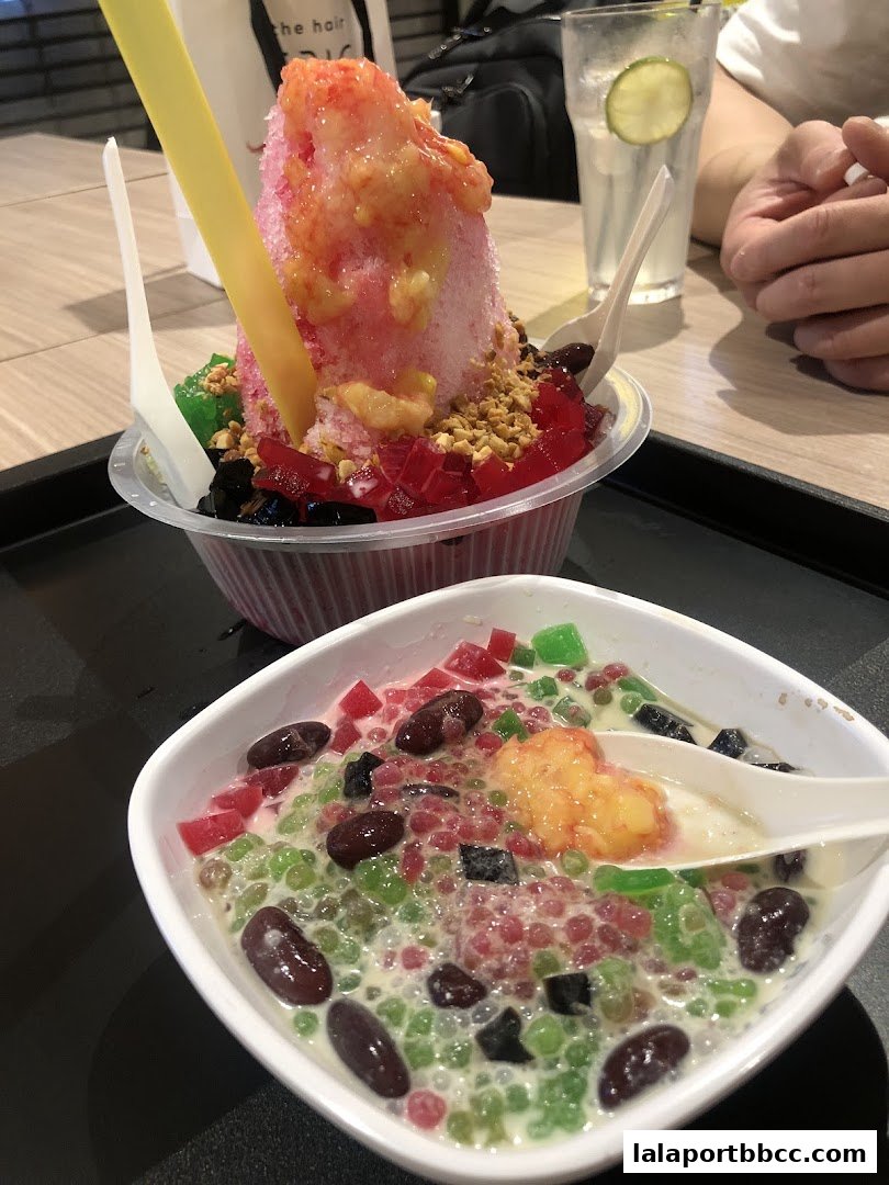 Two colorful and refreshing desserts, one shaved ice and one with tapioca pearls, served at a restaurant.