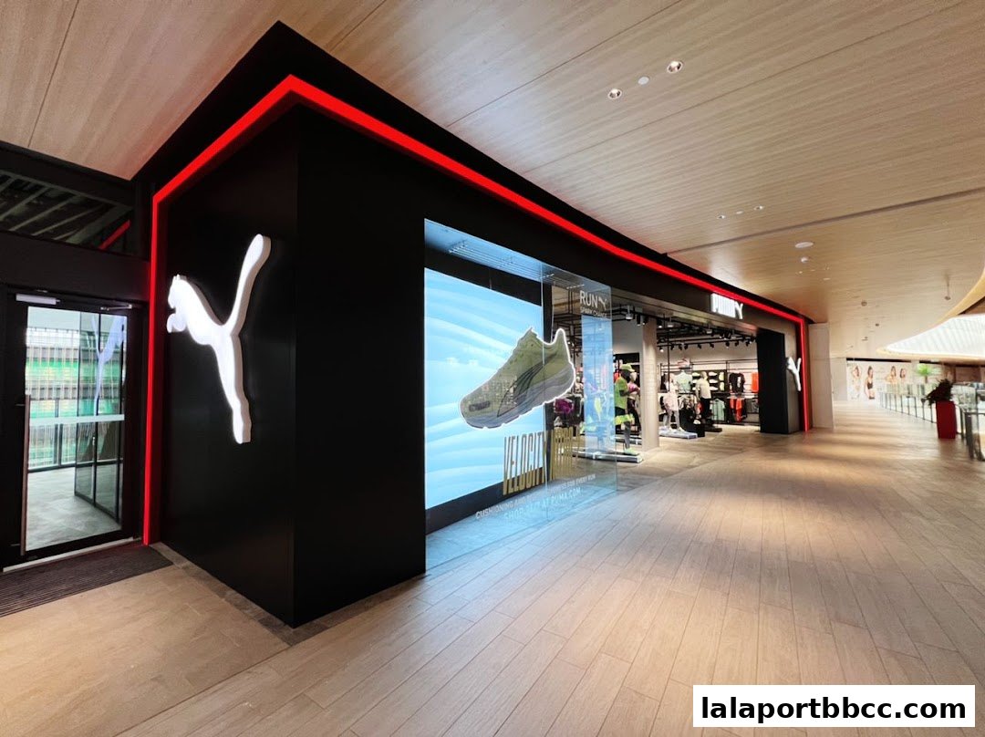 The modern PUMA store entrance with a large digital display showcasing a running shoe.