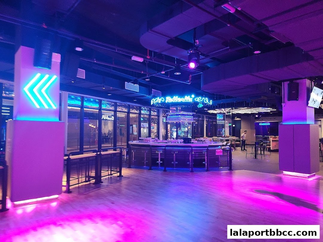 Interior of ROLLERWA Kuala Lumpur with neon lights, a bar, and seating areas.