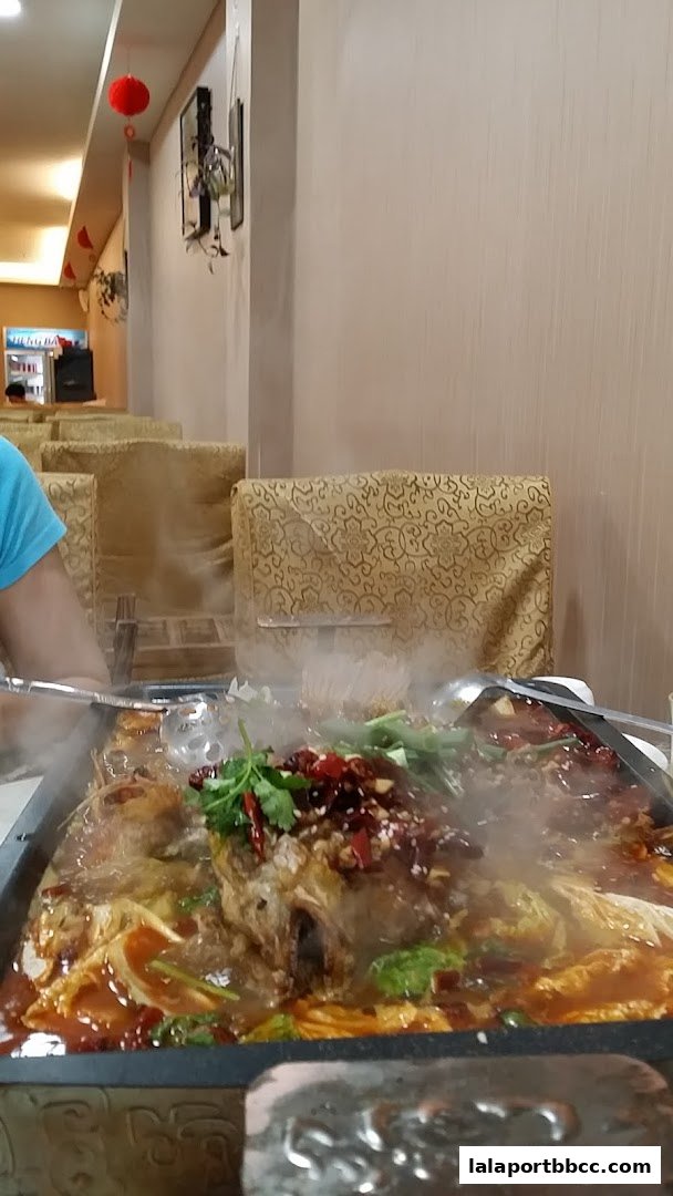 A steaming hot dish of fish with chili and vegetables is served at a restaurant.
