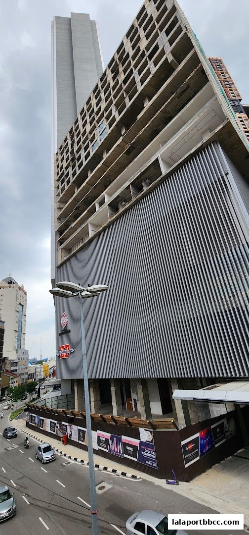 Exterior view of a modern building under construction with a linked bridge.