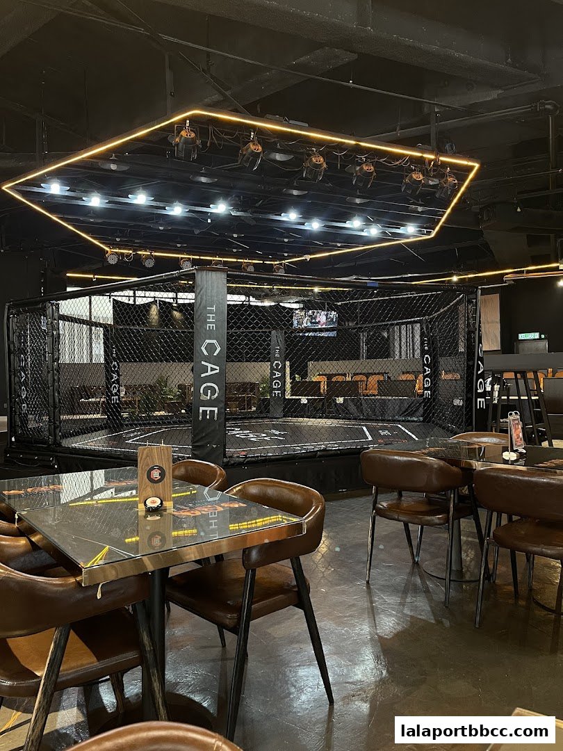 Interior of The CAGE - Duel Dine, featuring a boxing ring and dining tables.