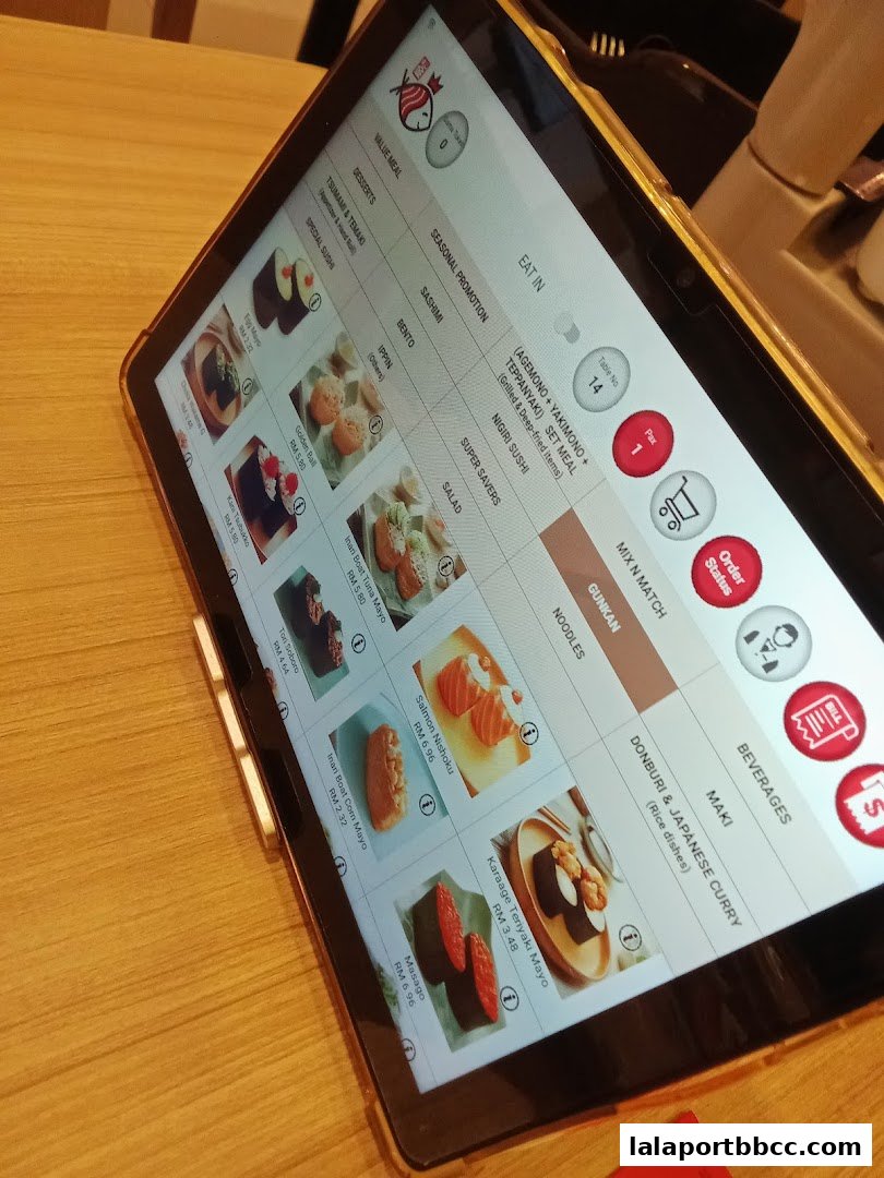 A tablet displays a digital menu for Sushi King Lalaport BBCC with various sushi and meal options.