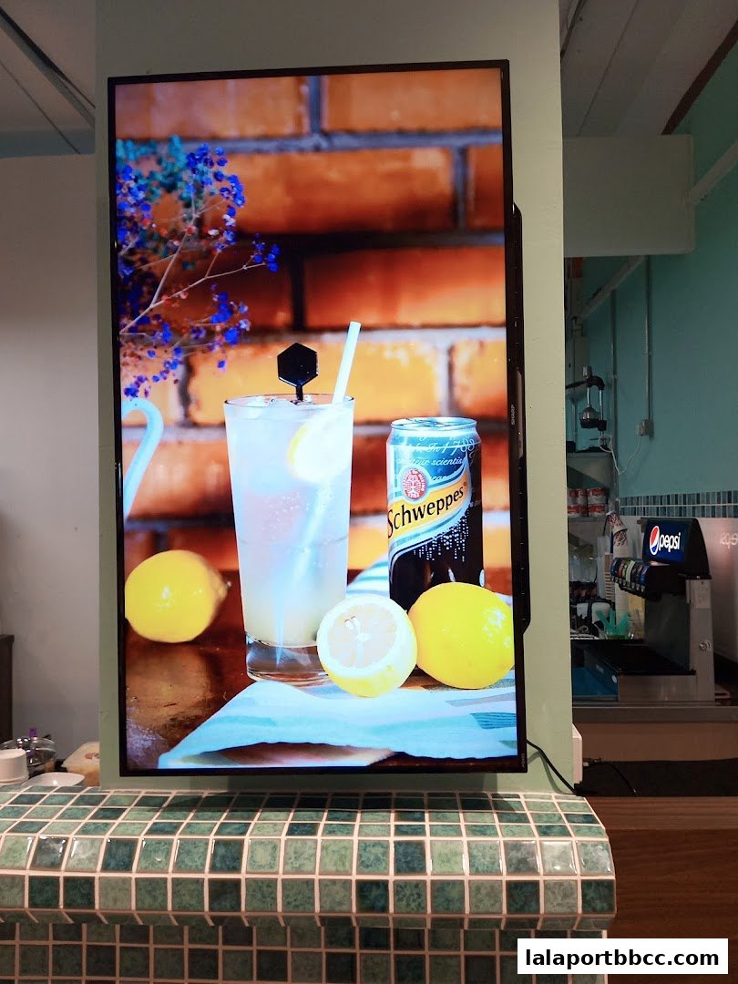 A digital display shows a refreshing drink with lemons and a can of Schweppes.