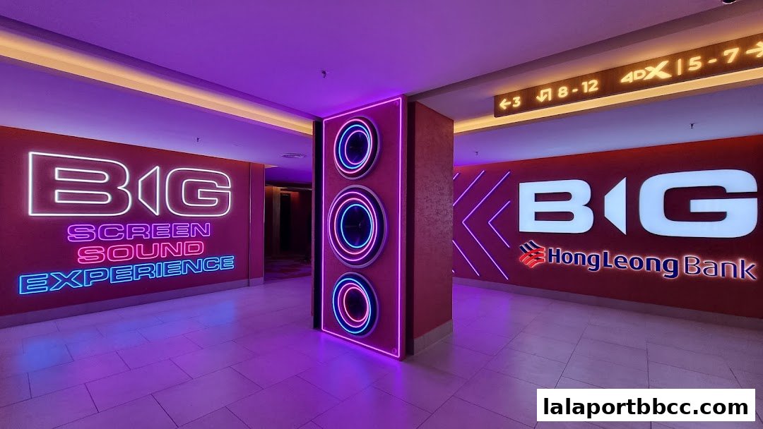 A brightly lit corridor with neon signs for BIG Screen Sound Experience and HongLeong Bank.