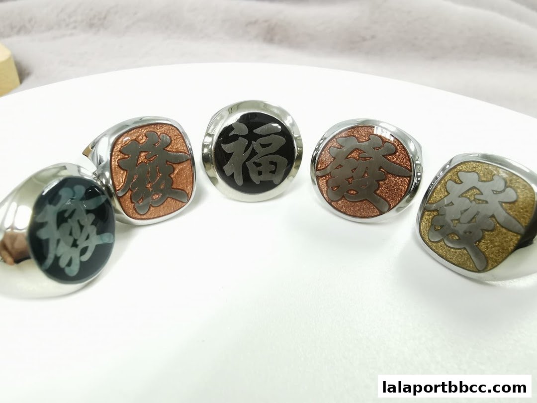 A collection of five stylish rings with Chinese characters on a white surface.