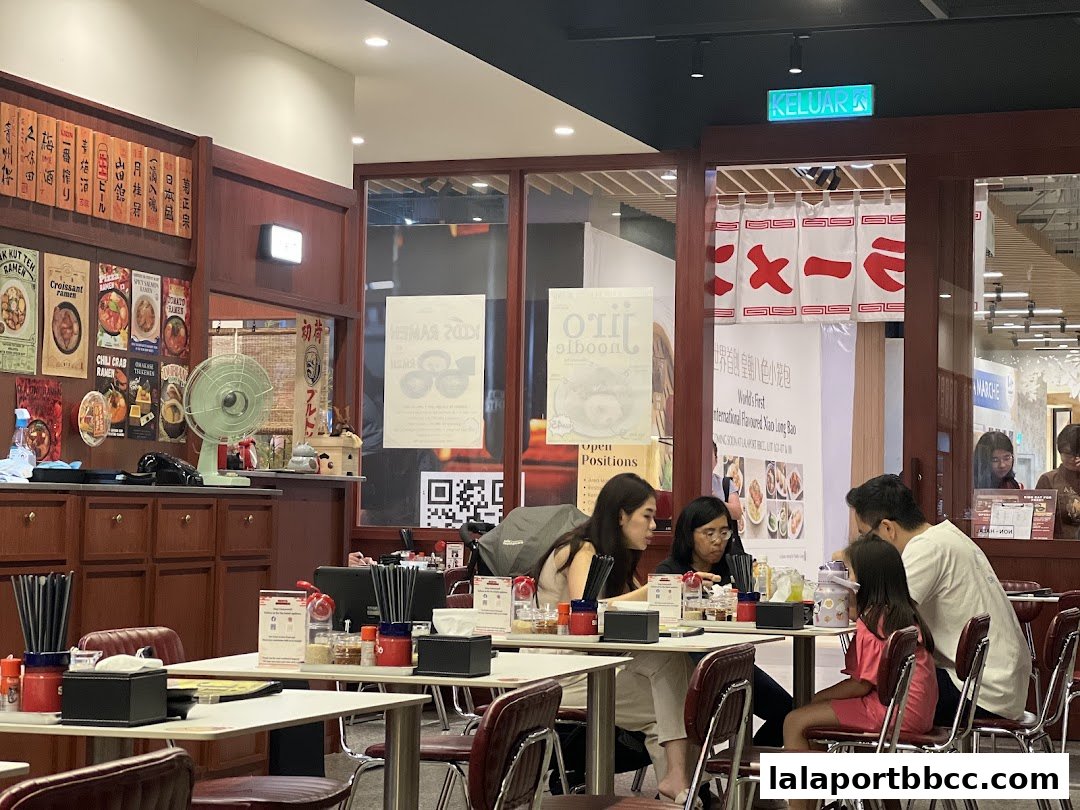 Diners seated at tables inside a Japanese ramen restaurant with traditional decor.