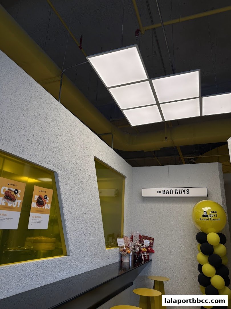 The interior of The Bao Guys restaurant with a counter, stools, and balloons.