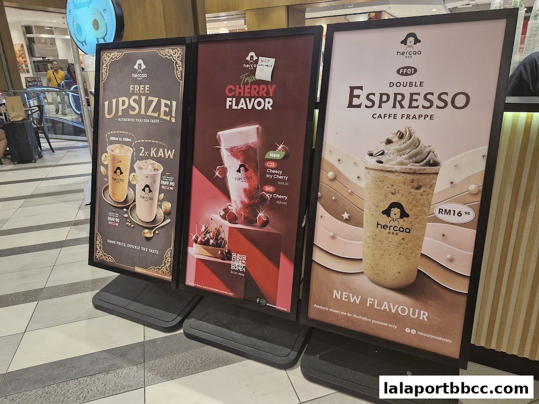 Three large display boards showcasing different beverage promotions from Hercaa.
