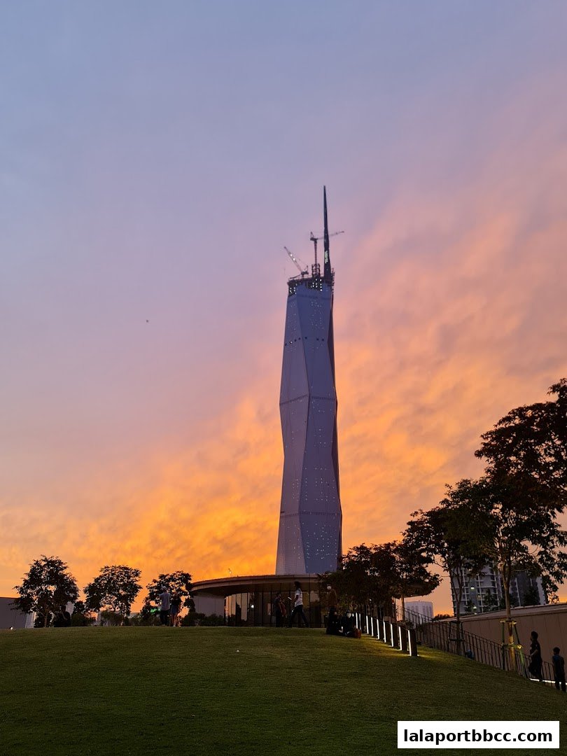 A striking skyscraper under construction against a vibrant sunset sky.