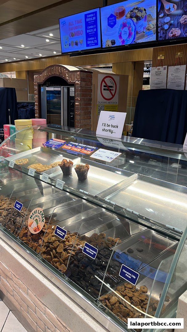 A display case filled with various cookies and muffins at Famous Amos.