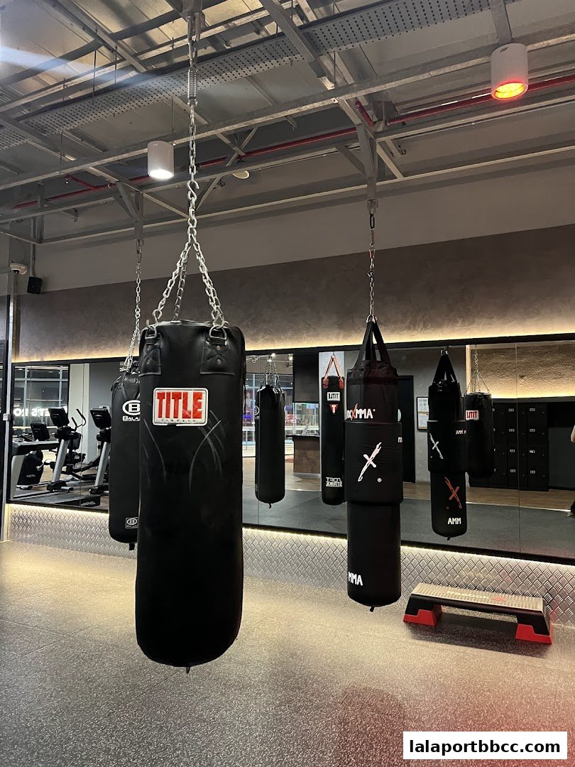 Interior view of a fitness center with multiple punching bags and exercise equipment.