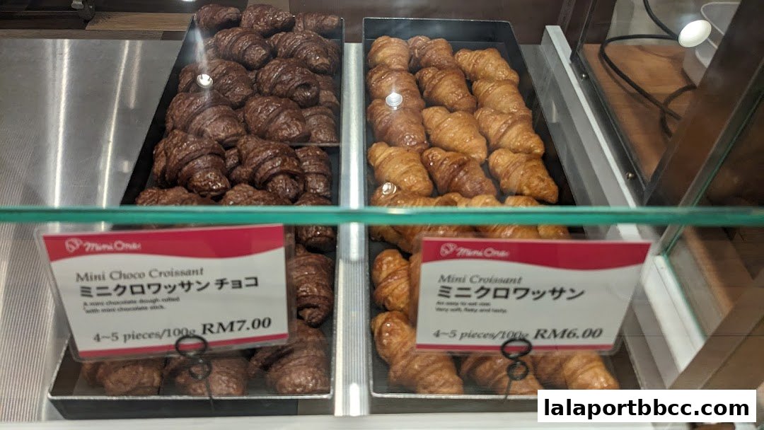 A display case filled with freshly baked mini croissants, both chocolate and plain.