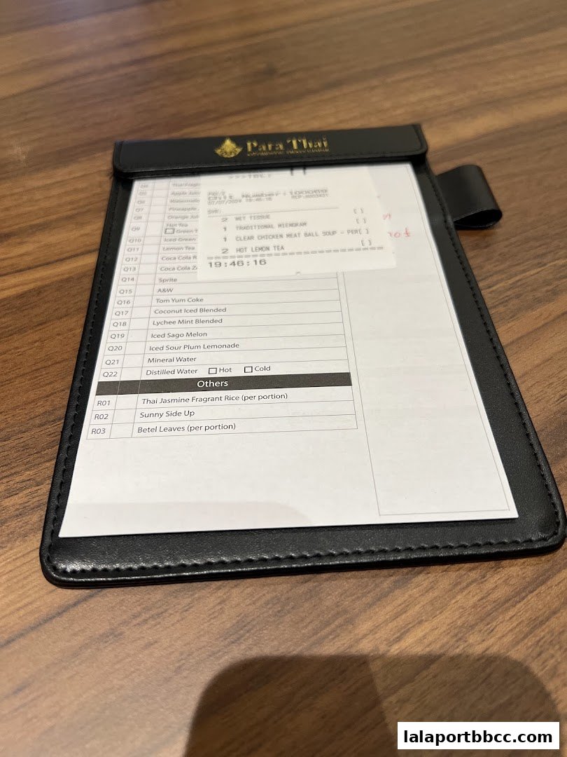 A close-up view of a Para Thai restaurant order slip with various food and drink items listed.