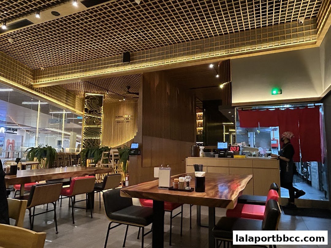 Interior of a modern Japanese restaurant with wooden tables, chairs, and decorative elements.