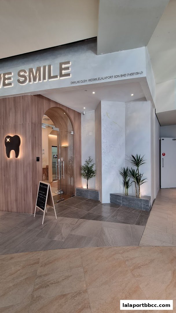 The entrance to WeSmile Dental Clinic, featuring a modern design with wood accents and a glowing tooth logo.