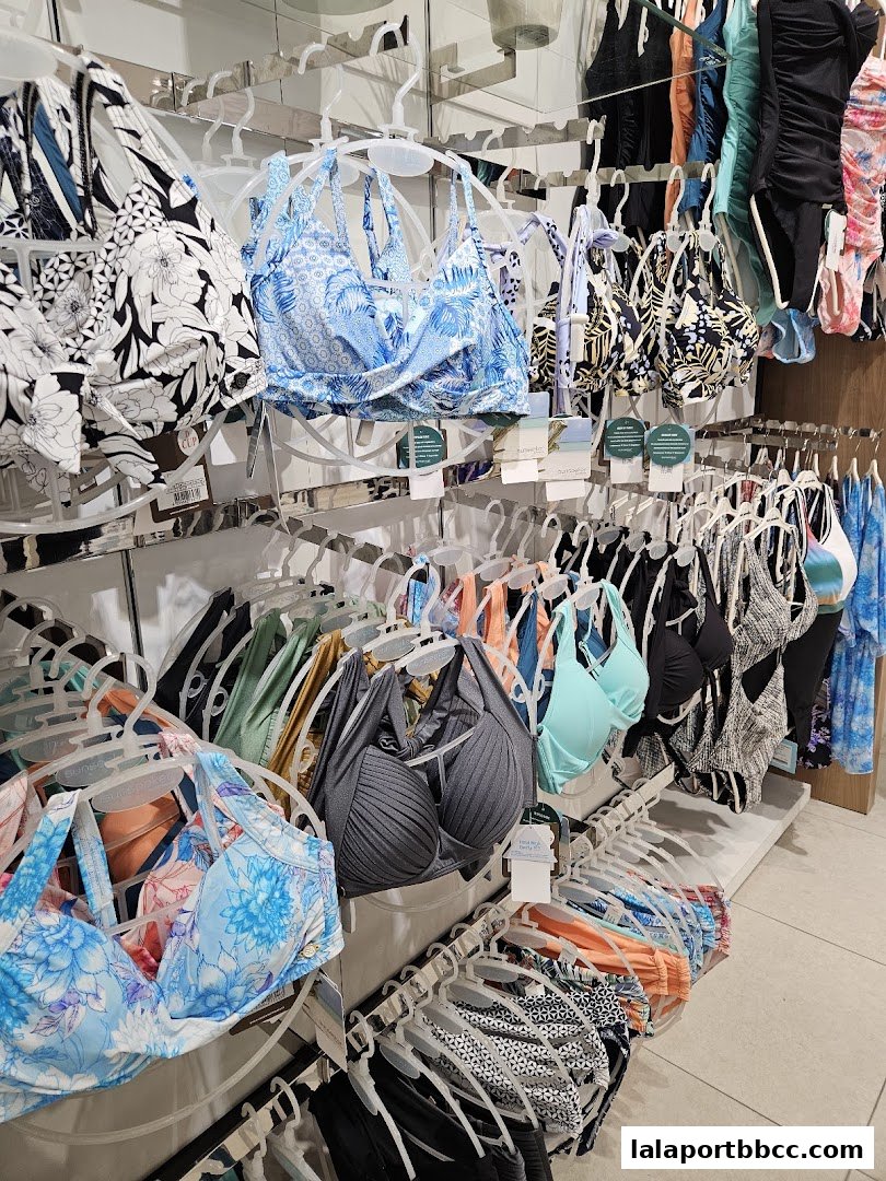 A display of various colorful bikini tops and swimsuits hanging on racks.