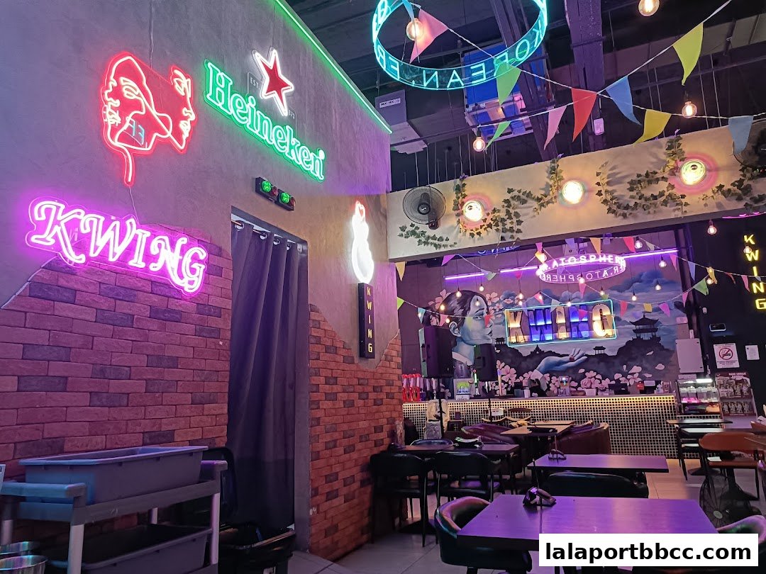 Interior of a Korean restaurant with neon signs, K-pop inspired decor, and seating.