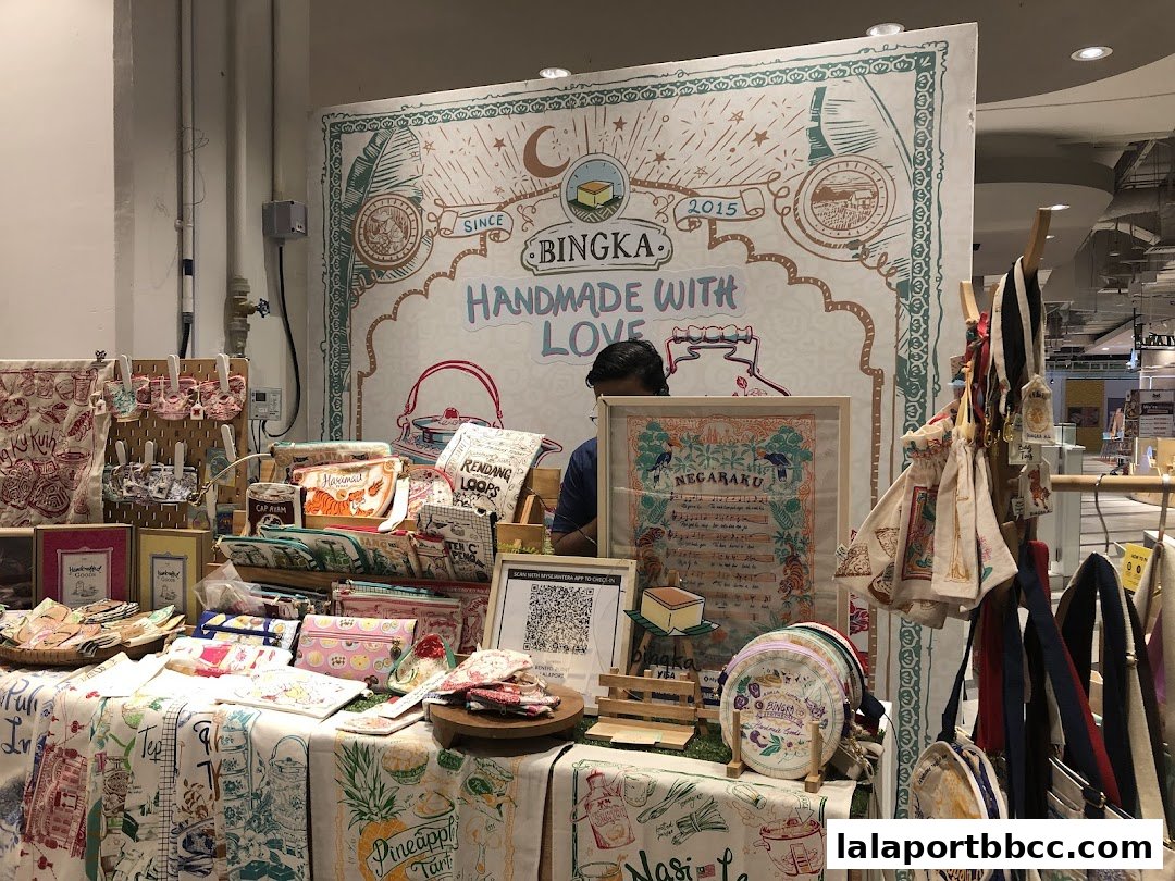 A stall displaying handmade pouches, bags, and fabric items with vibrant prints.