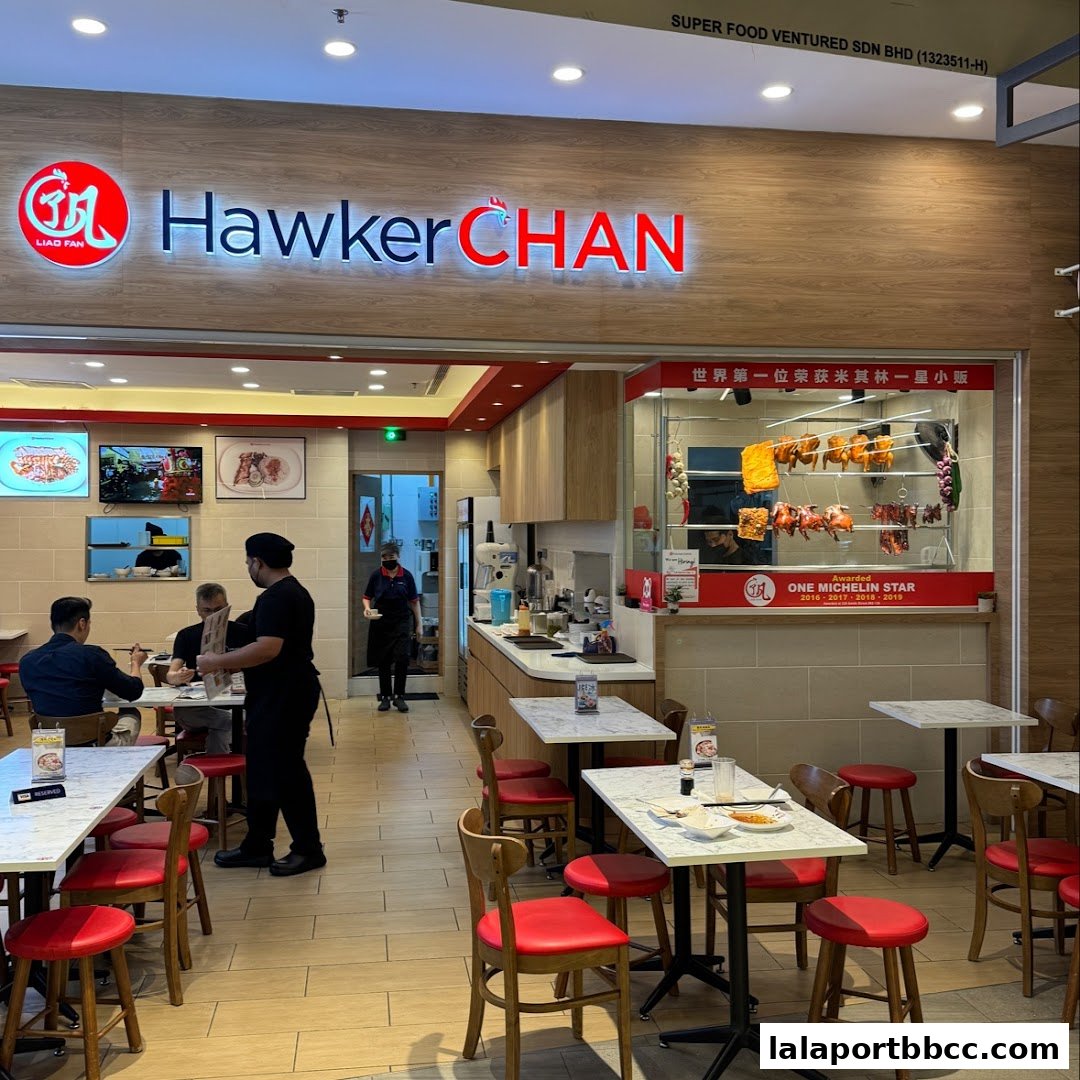 Interior view of Hawker Chan restaurant with tables, chairs, and the prominent restaurant signage.